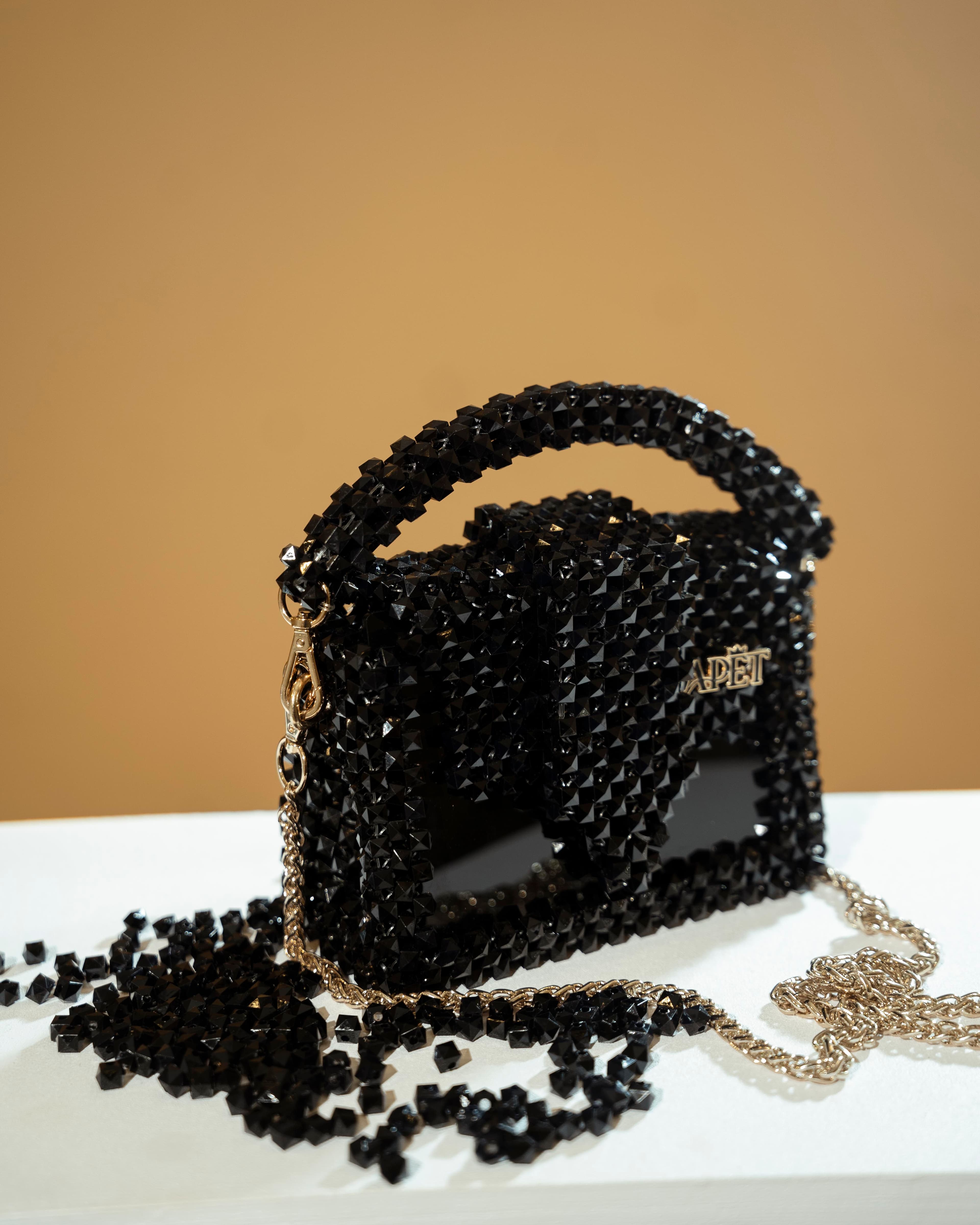 The Klair Black collection — a model in a black gown with gold woven detail